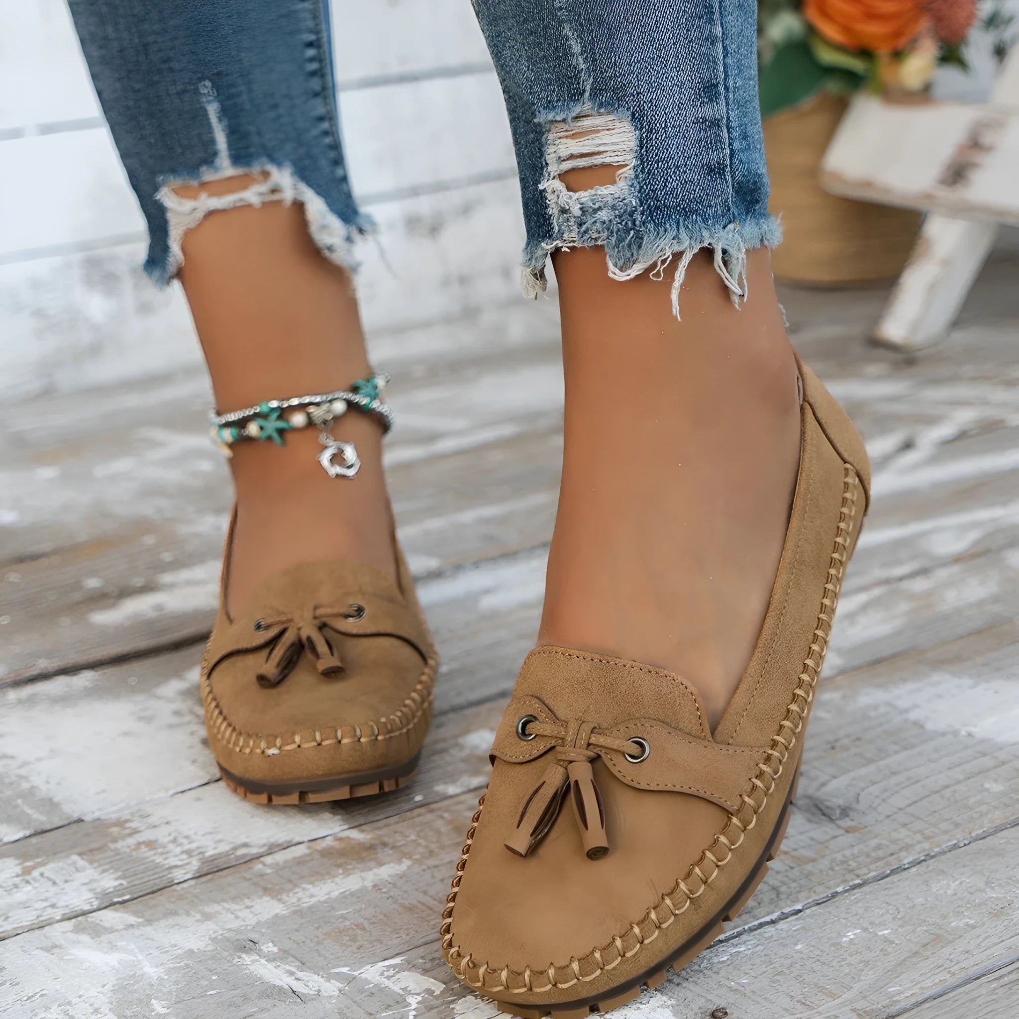 Women's suede flat shoes with a bow, shown in apricot colour, on a white background