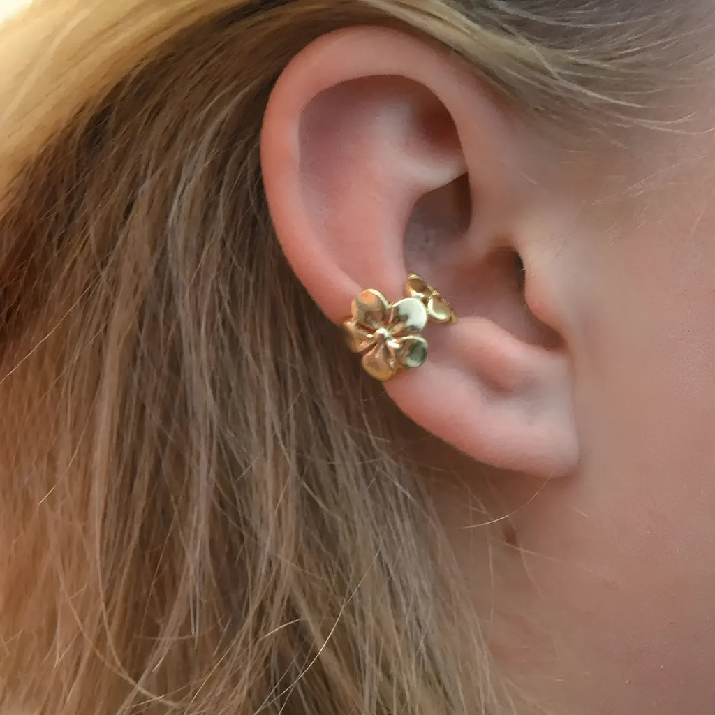 Women's gold starfish and conch shell drop earrings on a white background.