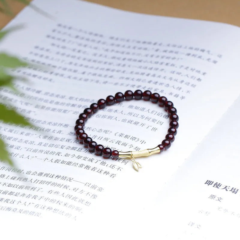 Natural garnet stone set in a 6mm wide bamboo joint bracelet with copper or silver metal finish.