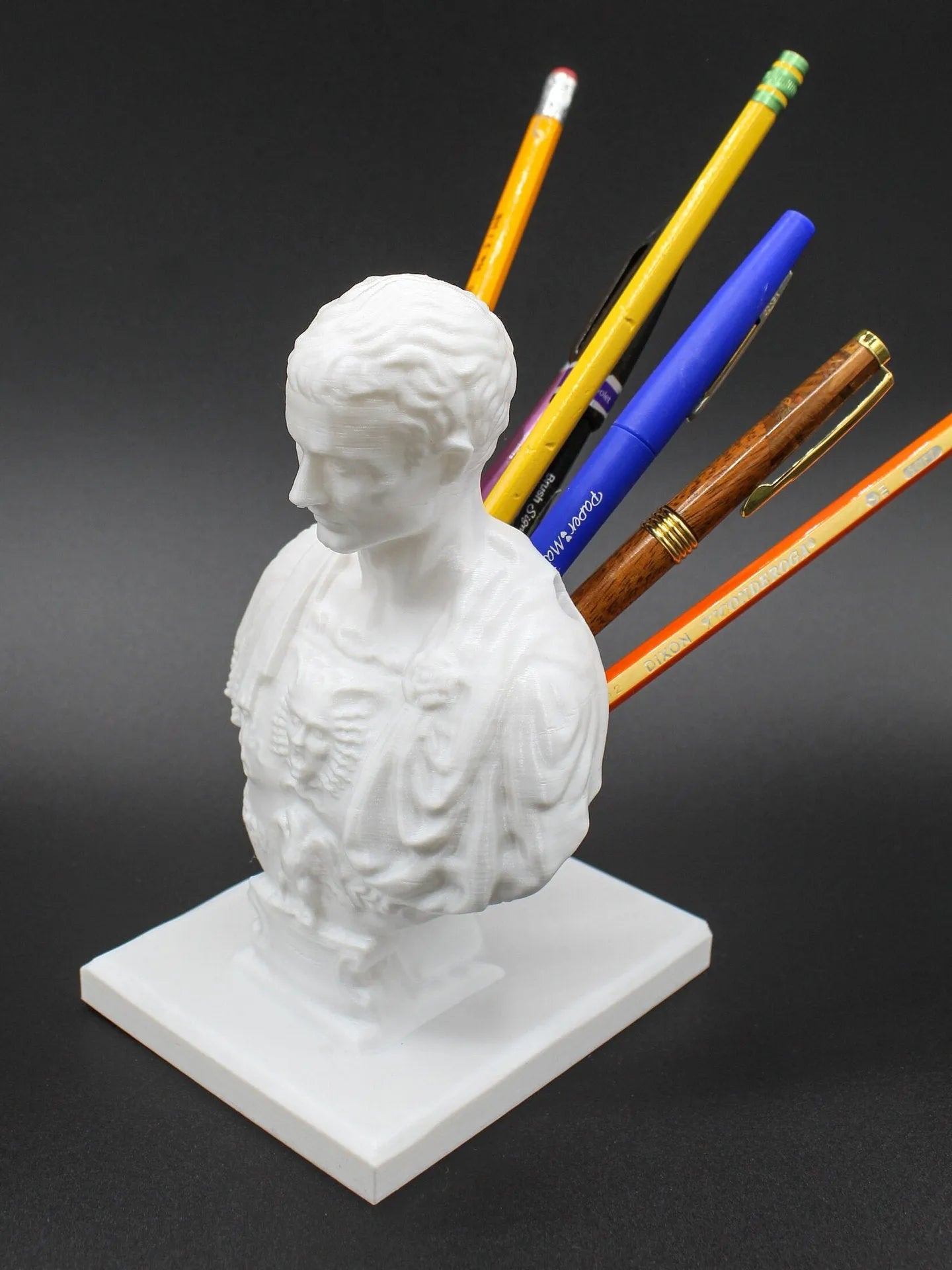 White synthetic resin American creative character modelling pen holder on a desk.