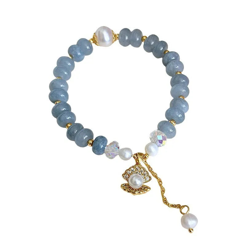 Natural aquamarine pearl shell bracelet on wrist showing adjustable design and handcrafted bead details