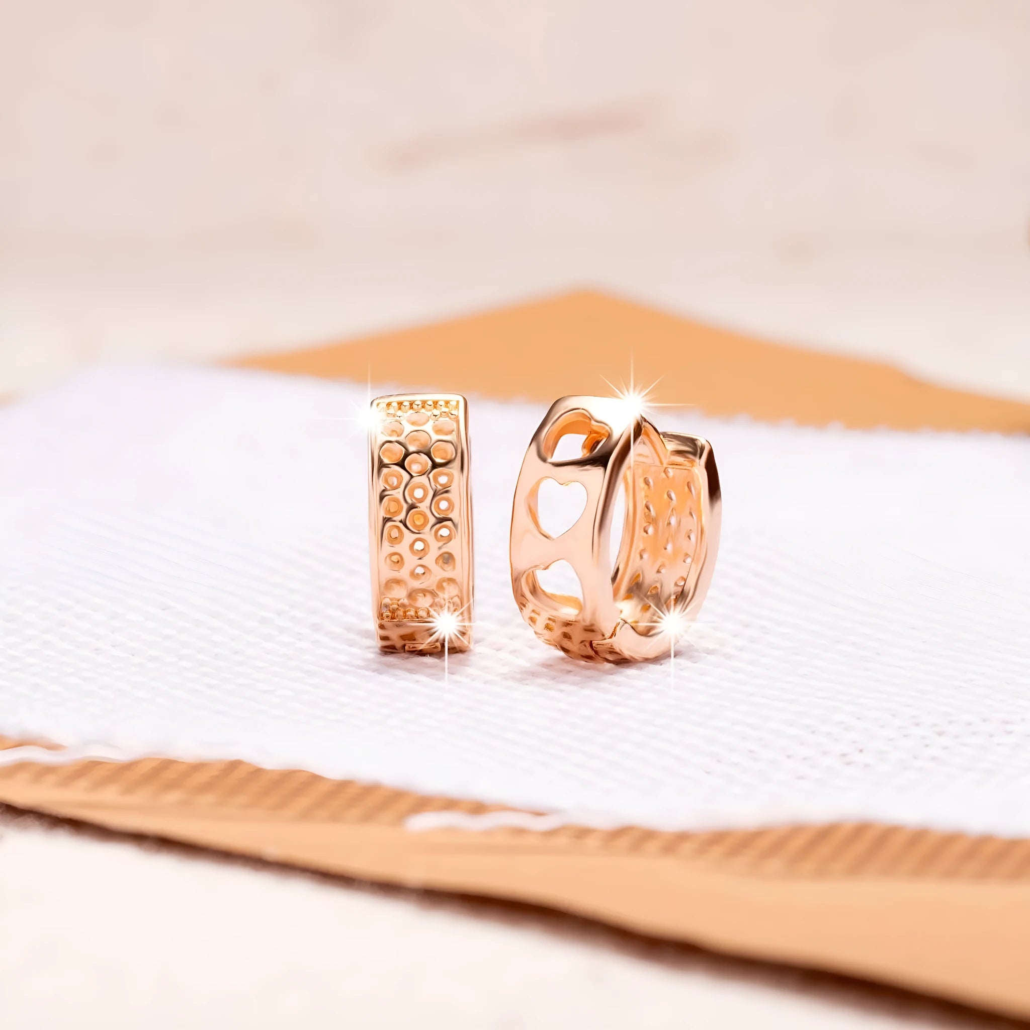 Rose gold hollowed out earrings with a three-heart design inside a circular shape.