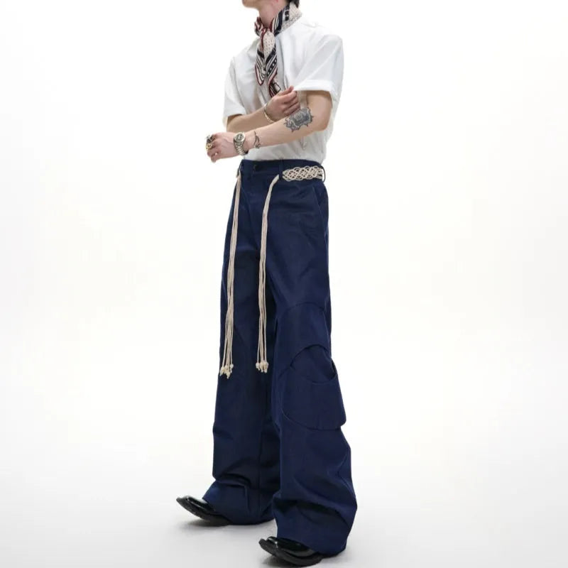 Men's dark blue straight-leg cotton jeans with heavy stitching on the belt and tassel pocket details.