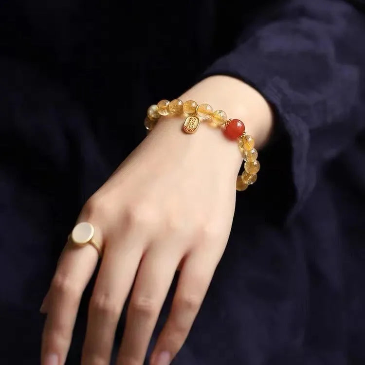 Red agate bracelet with gold ruby accents showing three bead size options on wrist