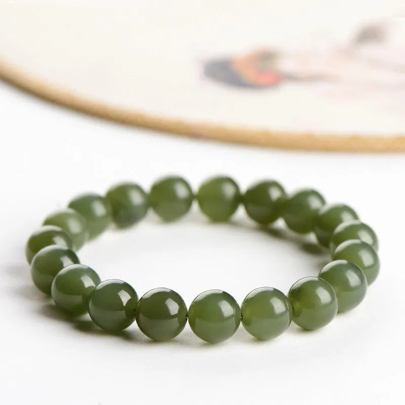 Polished Hetian jade ball bead bracelet in clear colour on wrist, showing spherical beads.