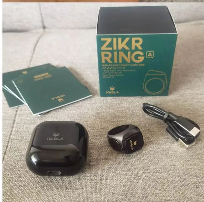 Zikr1 silver smart ring on a finger showing its OLED display and single button.