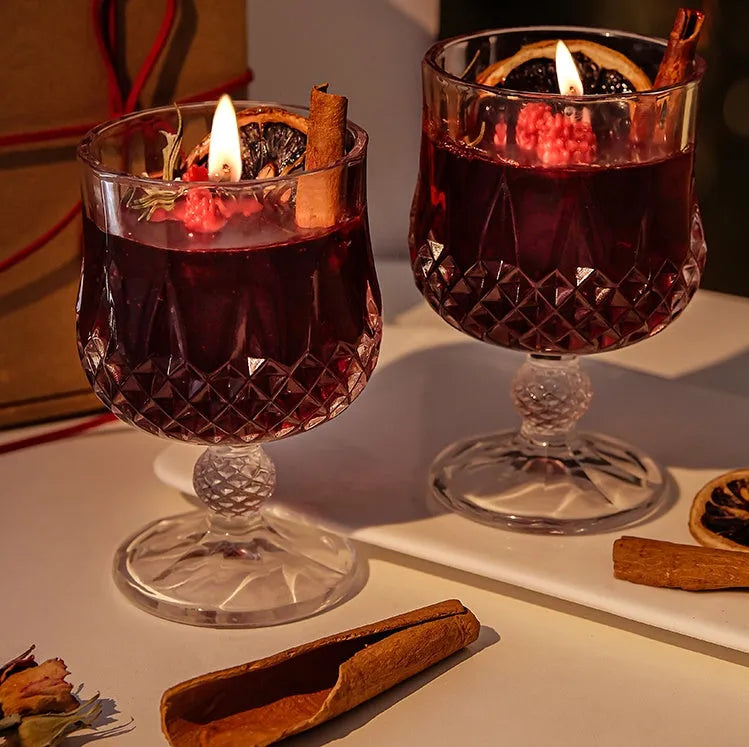 Clear glass wine goblet containing a scented candle with French mulled wine style