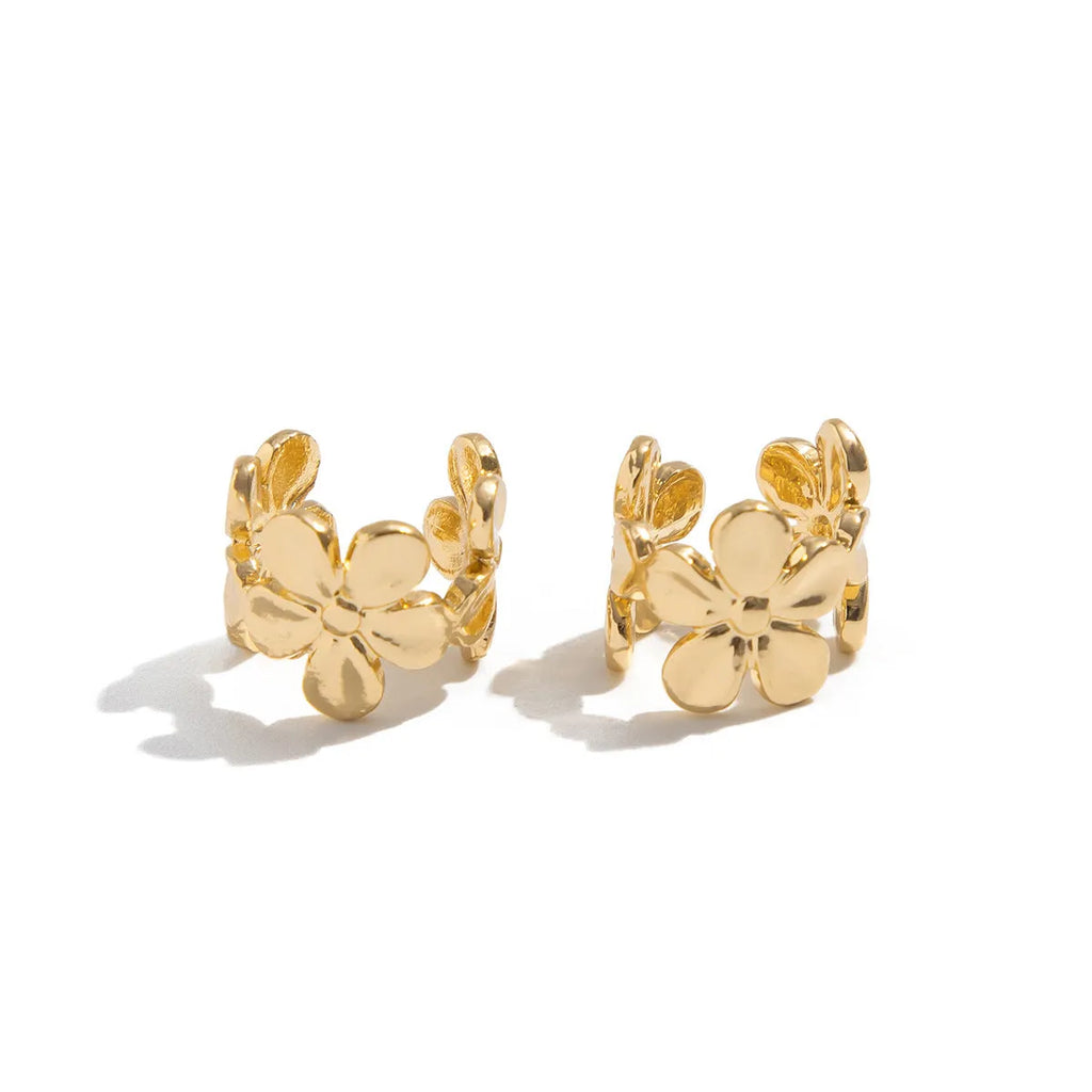 Women's gold starfish and conch shell drop earrings on a white background.