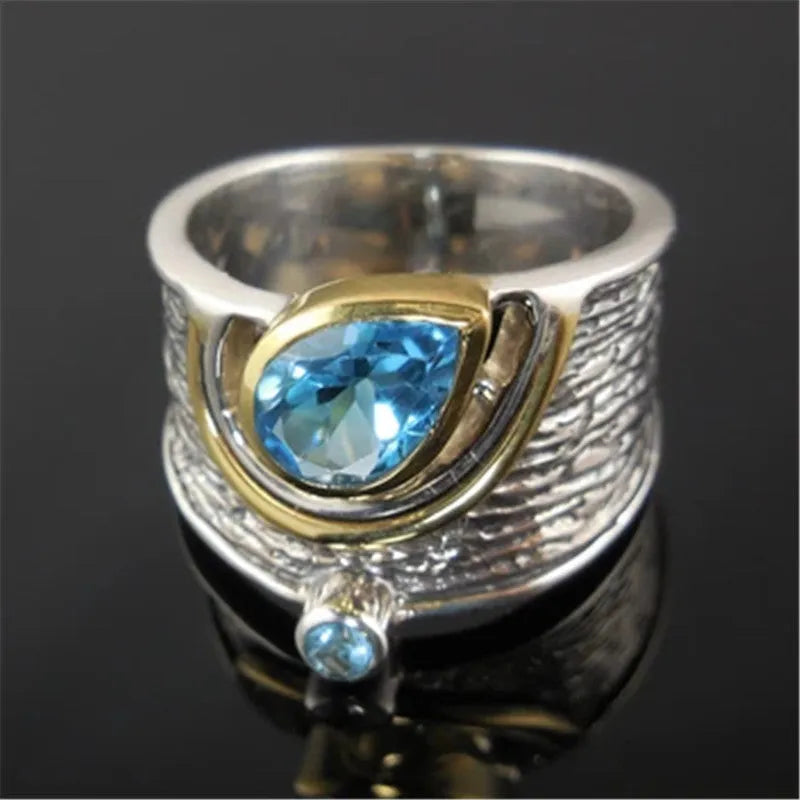 Women's blue zircon drop shape alloy ring with Chinese style design on a white background.