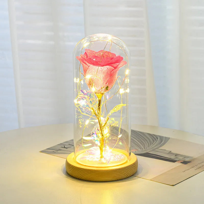 Red eternal rose in glass dome with warm white LED light string on bendable copper wire