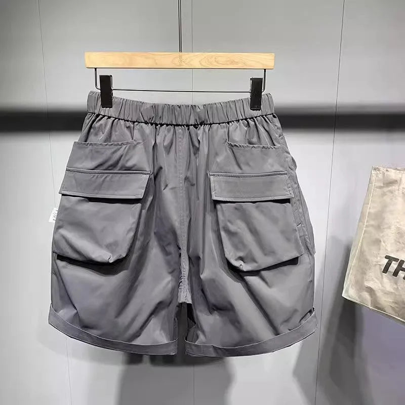 Men's large size loose fitting black shorts with pockets and straight leg hem.