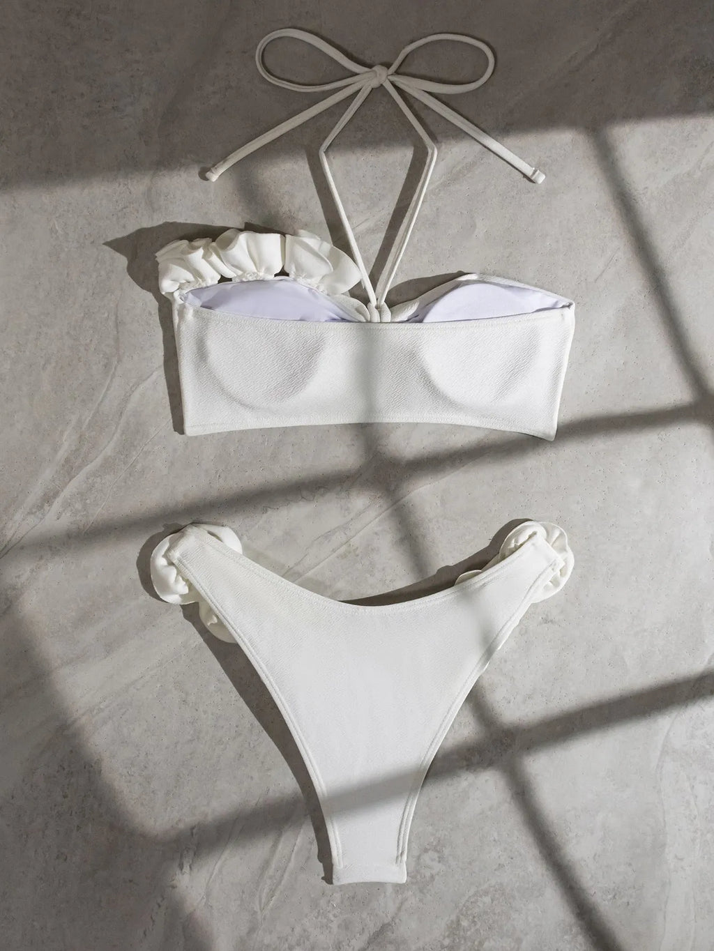 White halter neck lace-up bikini with three-dimensional floral embroidery and brief bottoms.