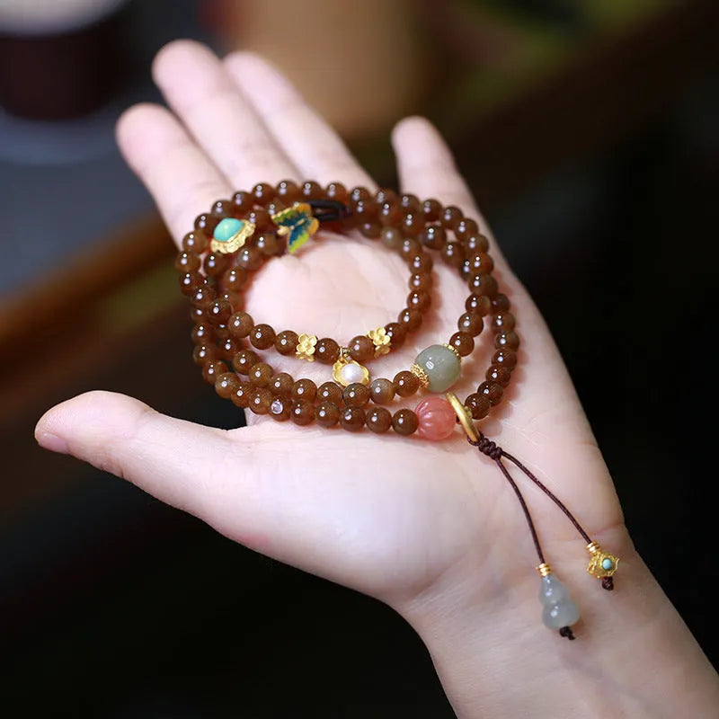 Brown Jade Hetian jade bracelet with butterfly, gourd, and pearl three-ring design and silver-plated fittings.