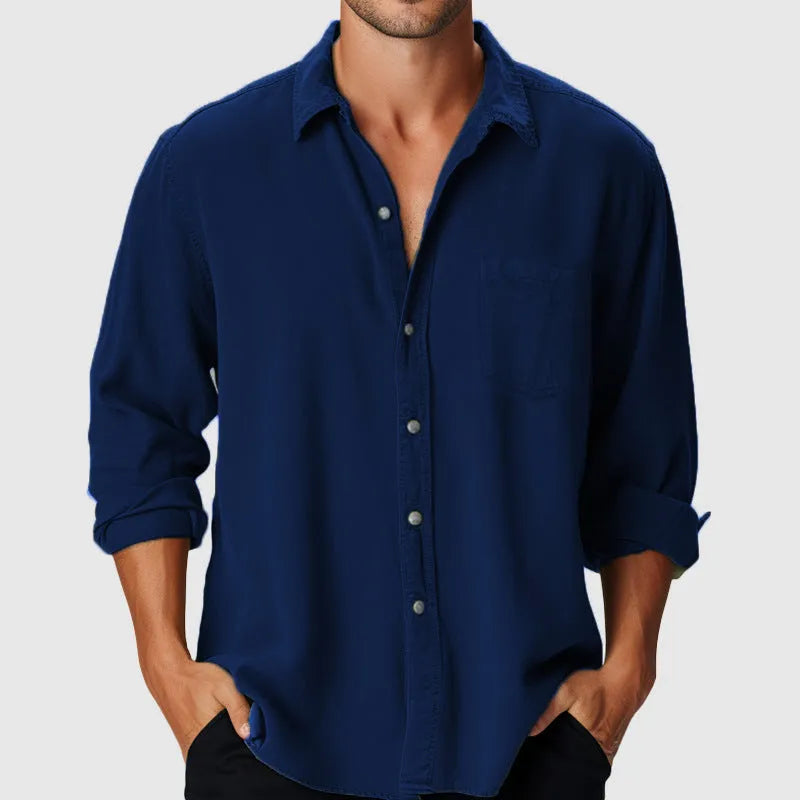 Man wearing a loose-fit, long-sleeve polyester shirt with a stand collar on a beach.