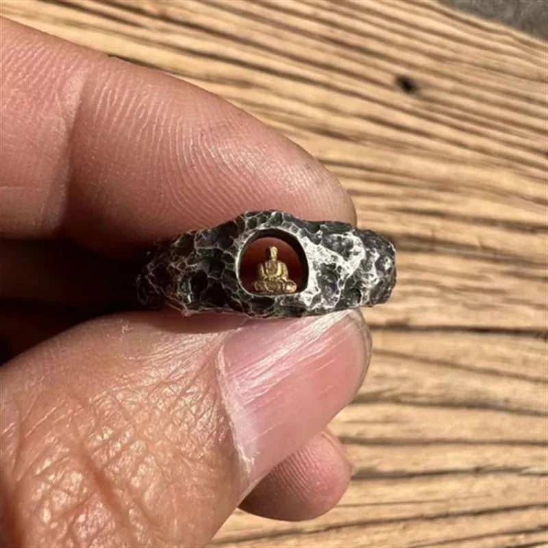 Close-up of a hand-forged copper ring with a textured Grotto Buddha and rock pattern.