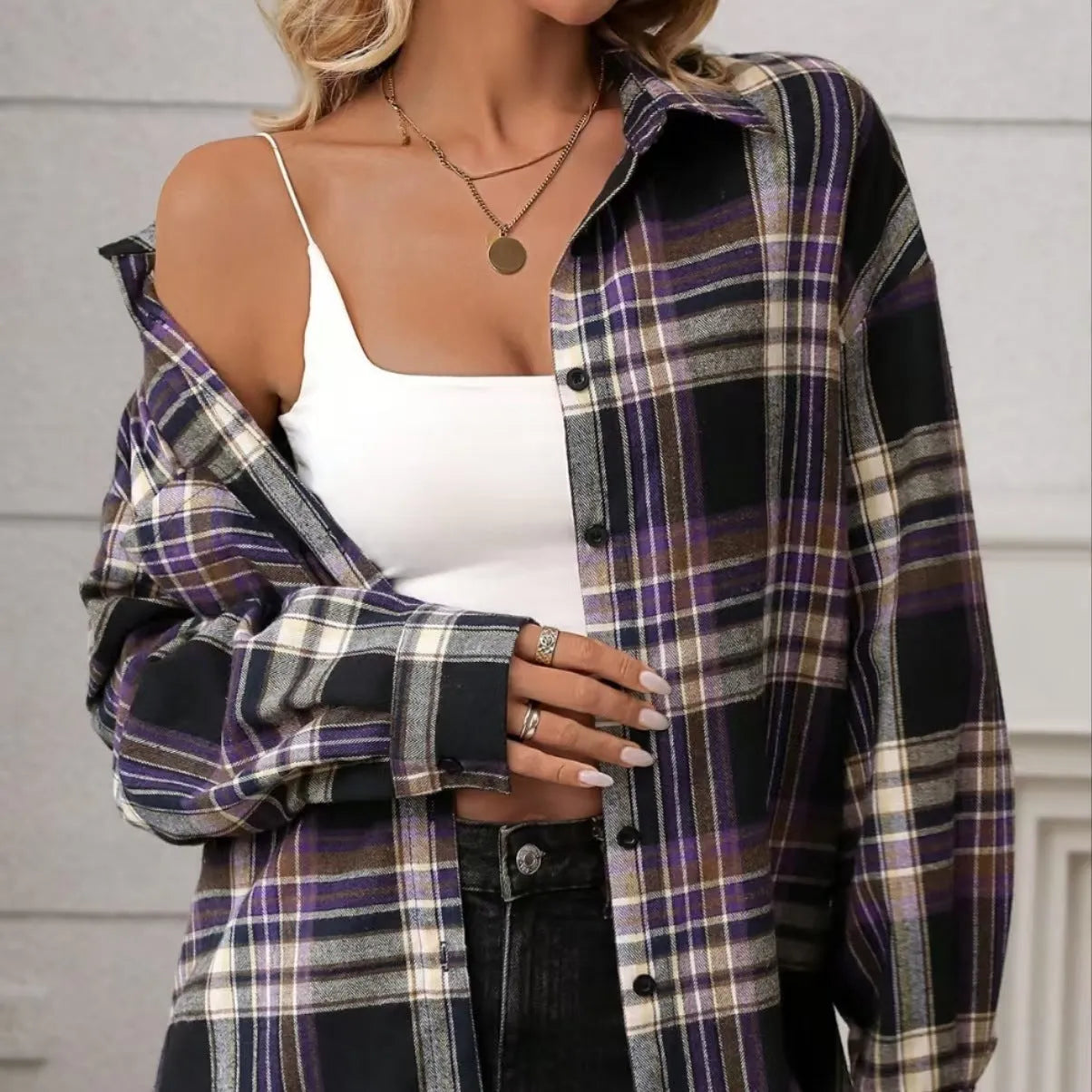 A woman's loose fit cotton plaid shirt in a retro style, shown in a choice of black, green, or purple colours.