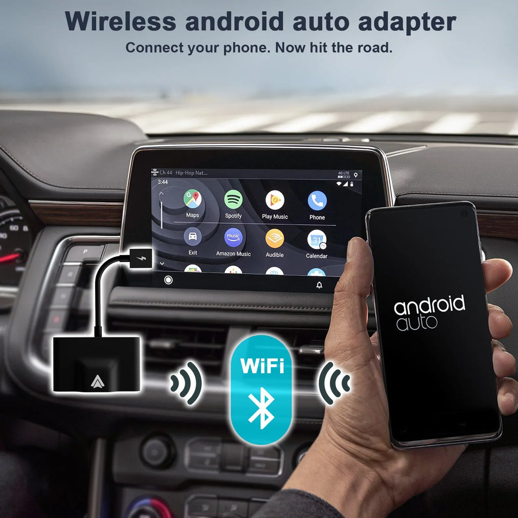 Black and white wireless Carplay adaptor for Android phones next to a car steering wheel