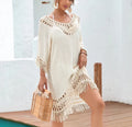 Apricot coloured crocheted patchwork beach dress on a hanger, showing mid-length skirt and half sleeves.