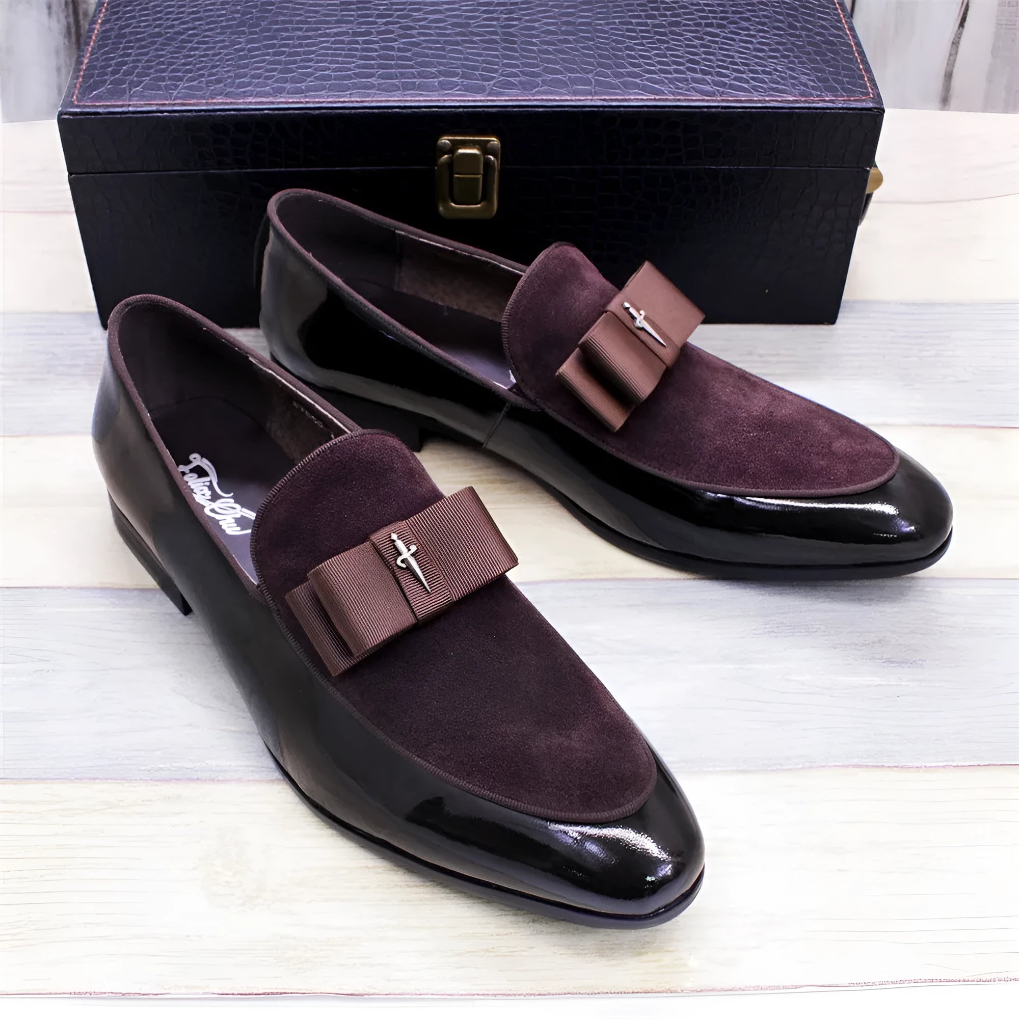 Men's black low-top leather brogue shoes with a patent leather finish and tassel detail on a rubber sole.