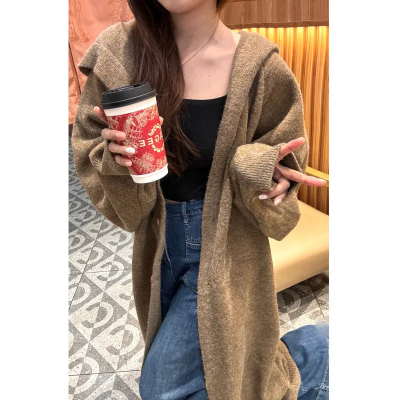 Women's long brown hooded knitted cardigan with a below-the-knee length and loose fit.