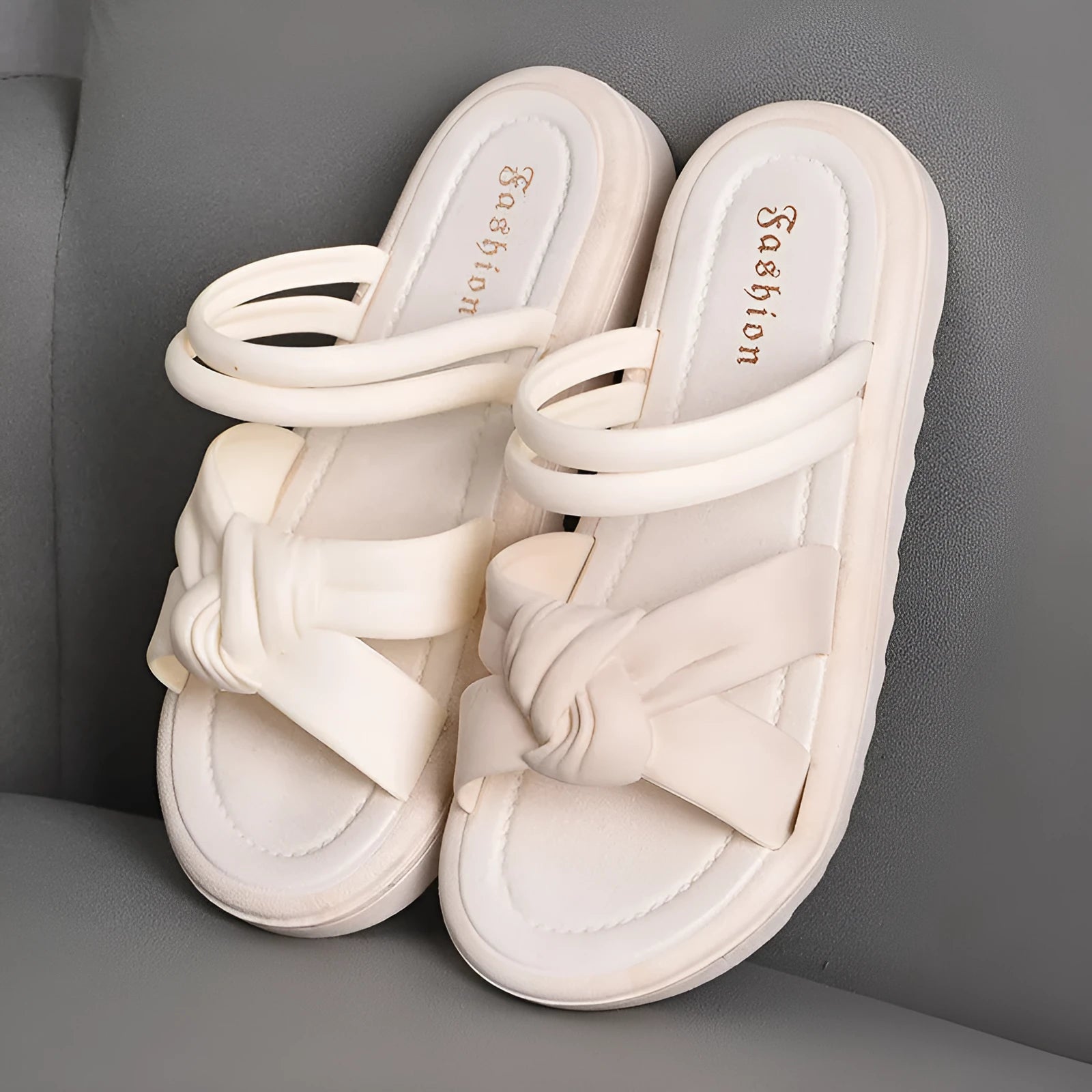 Women's black PVC sandals with soft back, floral detail, and a thick height-increasing sole.
