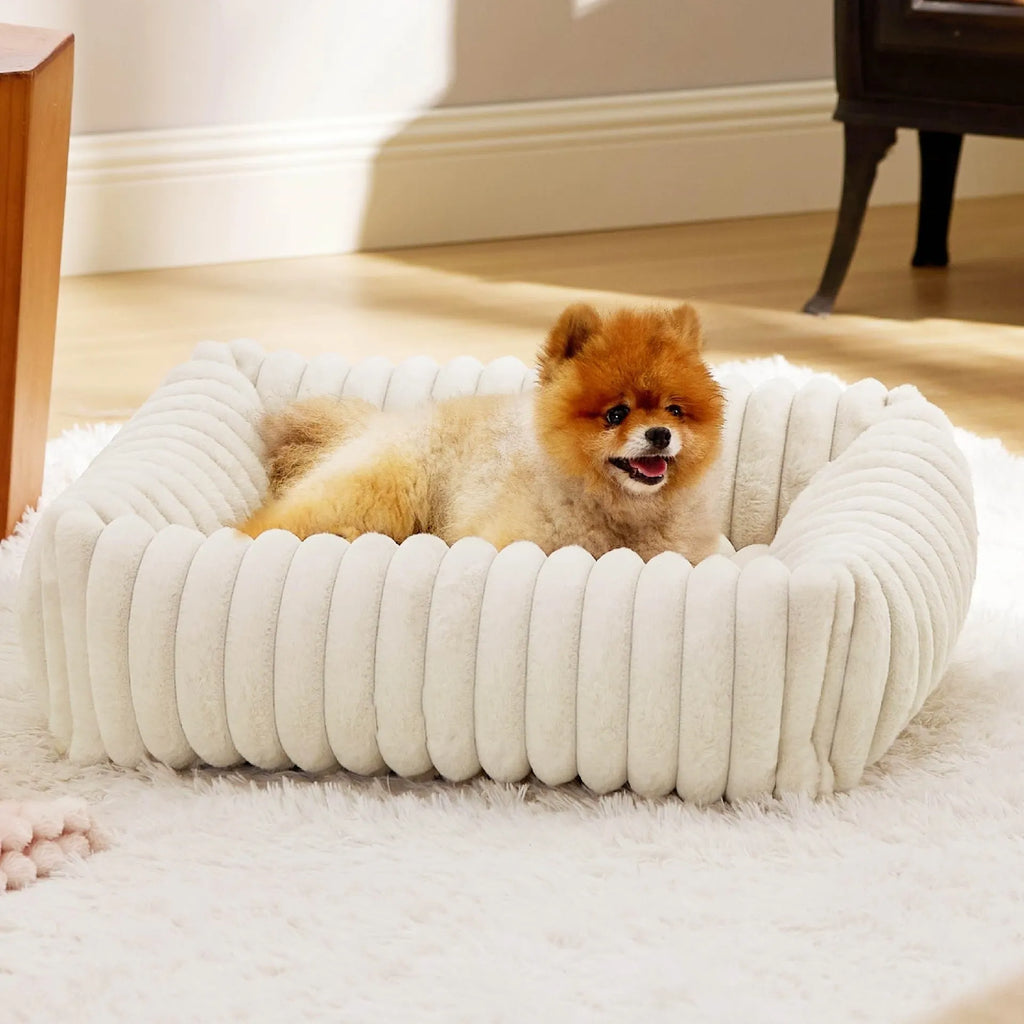 Grey pet bed with raised cushioned sides for a cat or dog.