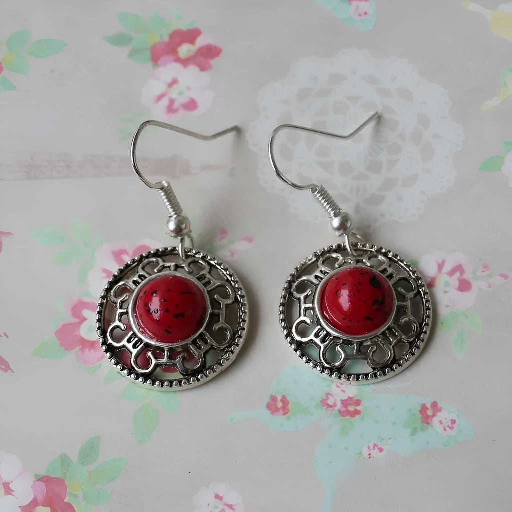 Handmade Miao ethnic style silver earrings with a blue turquoise flower disk and geometric patterns.