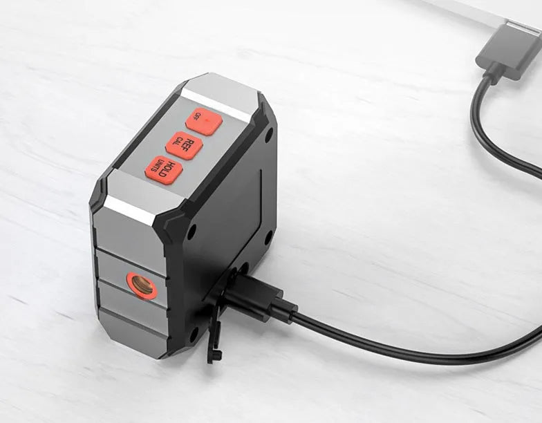 Longyun digital laser tape measure with alloy casing and backlit display on a workbench.