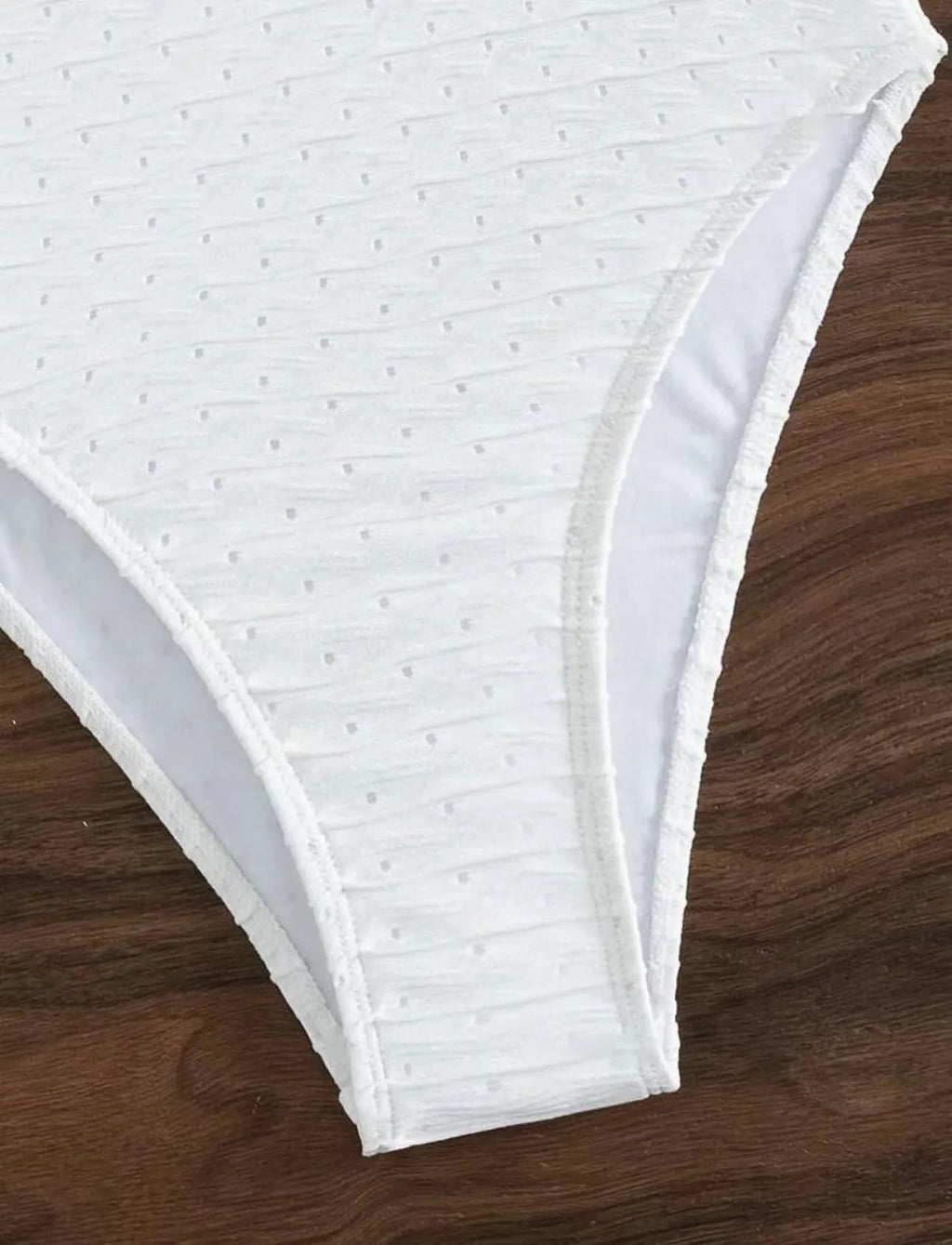 White one-piece sling-back swimsuit for women on a mannequin, showing briefs style.