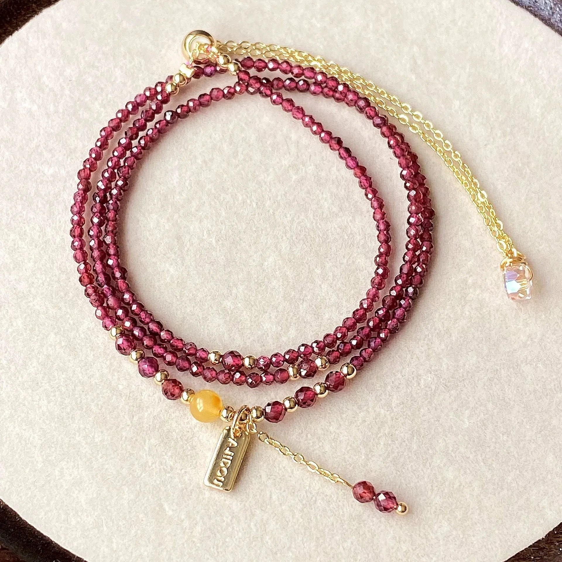 Wine red garnet bracelet with three circle design showing 2.5mm cut stone beads and electroplated metal