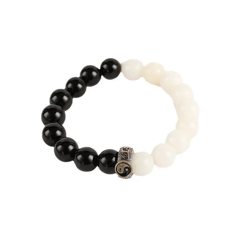 Black and white Taiji symbol bracelet made from obsidian beads with engraved mantra.