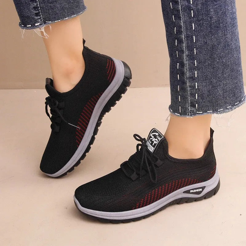 Women's black mesh sneakers with cross straps, round toe, and lace-up front on a rubber sole.