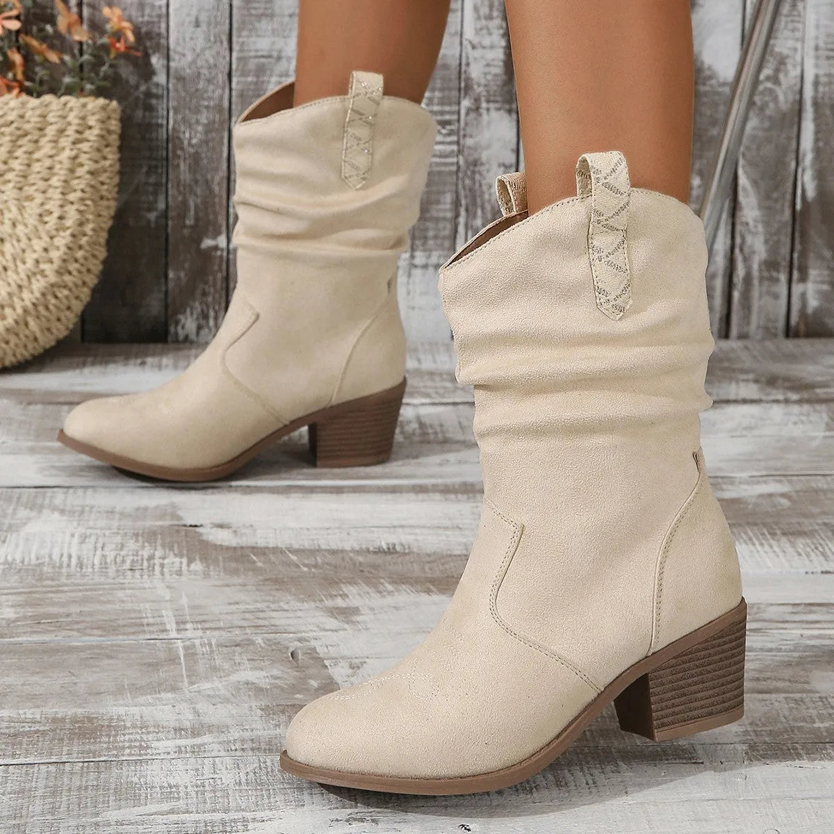Milky white suede mid-calf boots with leather stitch detail and a mid-heel on a woman.