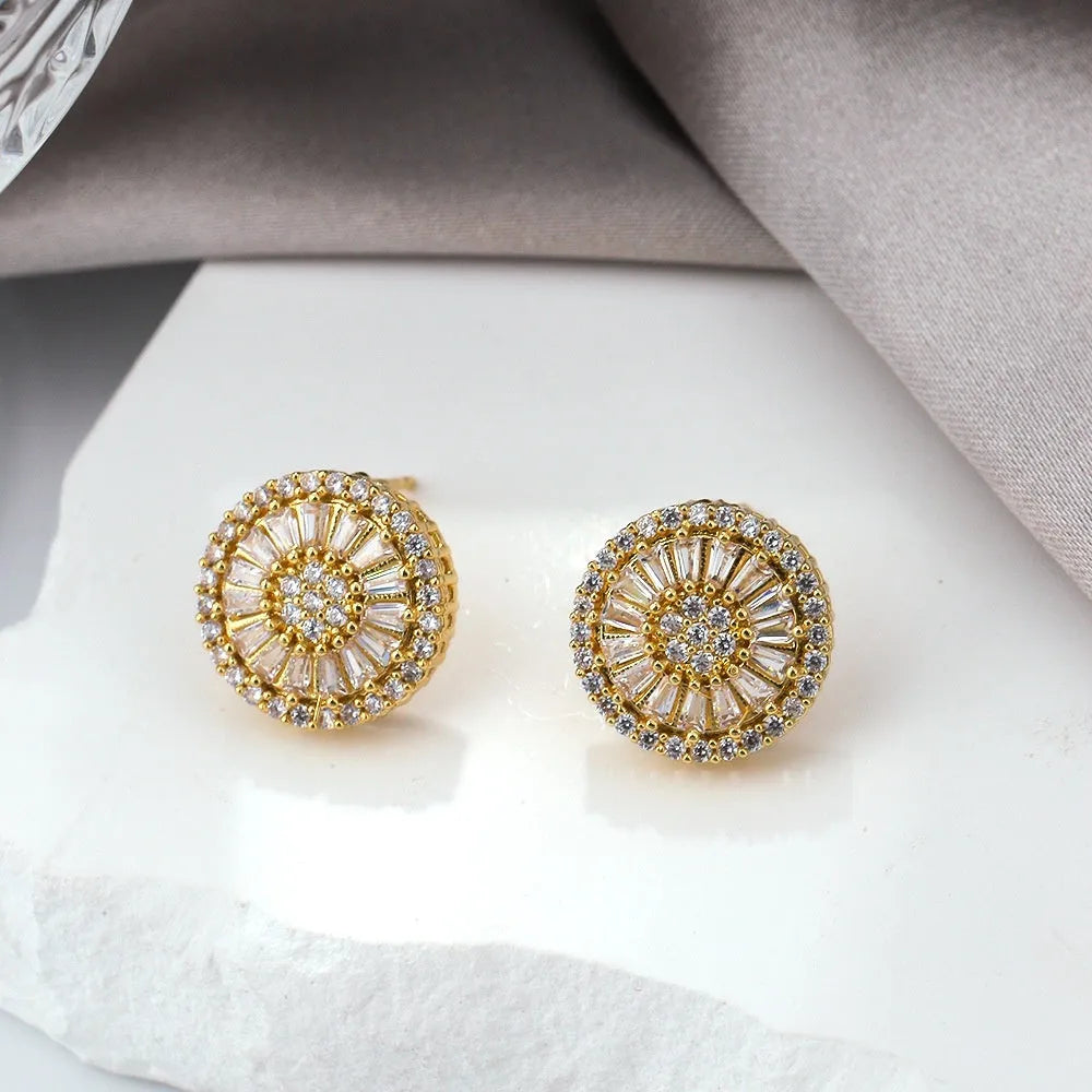 Geometric gold electroplated earrings with a round pattern design.