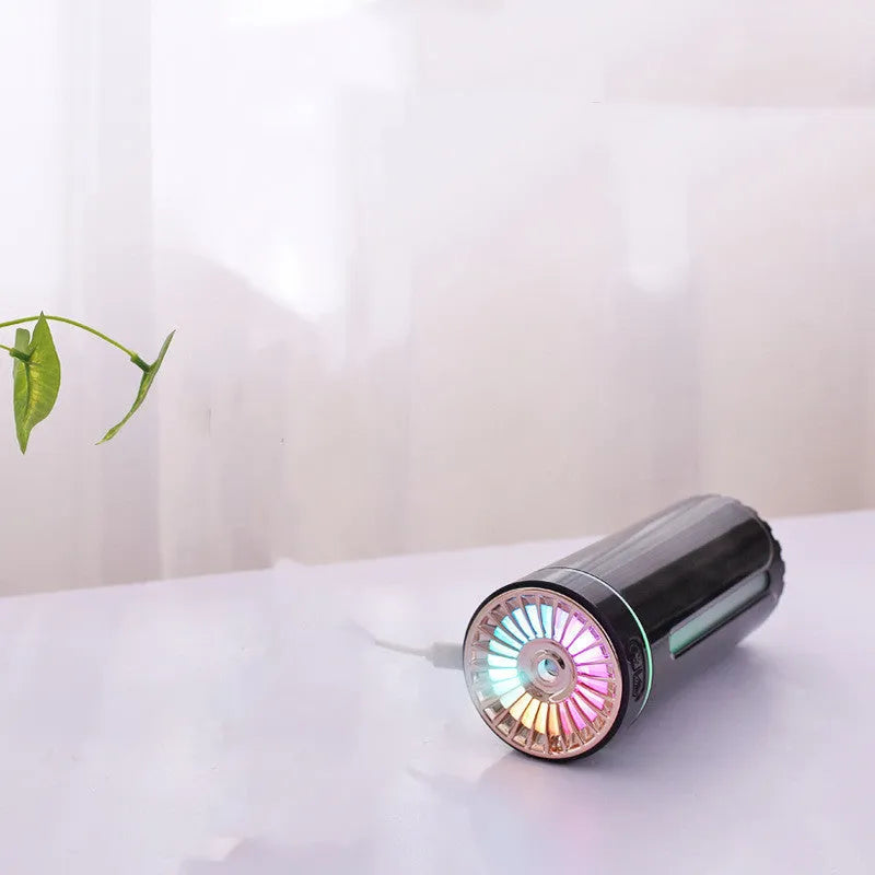 Black portable ultrasonic humidifier with colourful LED lights on a car cup holder.