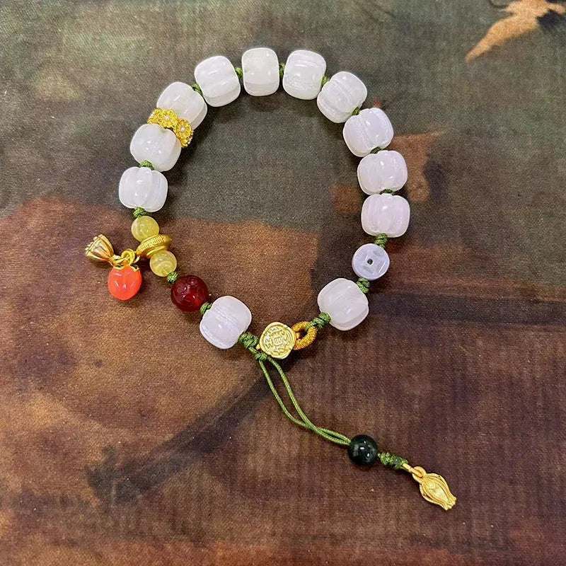 White jade Bodhi bracelet with lotus beads and a large pumpkin bead on an open rope.