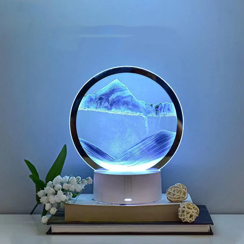 Blue 3D quicksand touch table lamp with glass shade on a wooden desk.