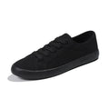 All black low top canvas lace-up shoes with a flat rubber sole for women.