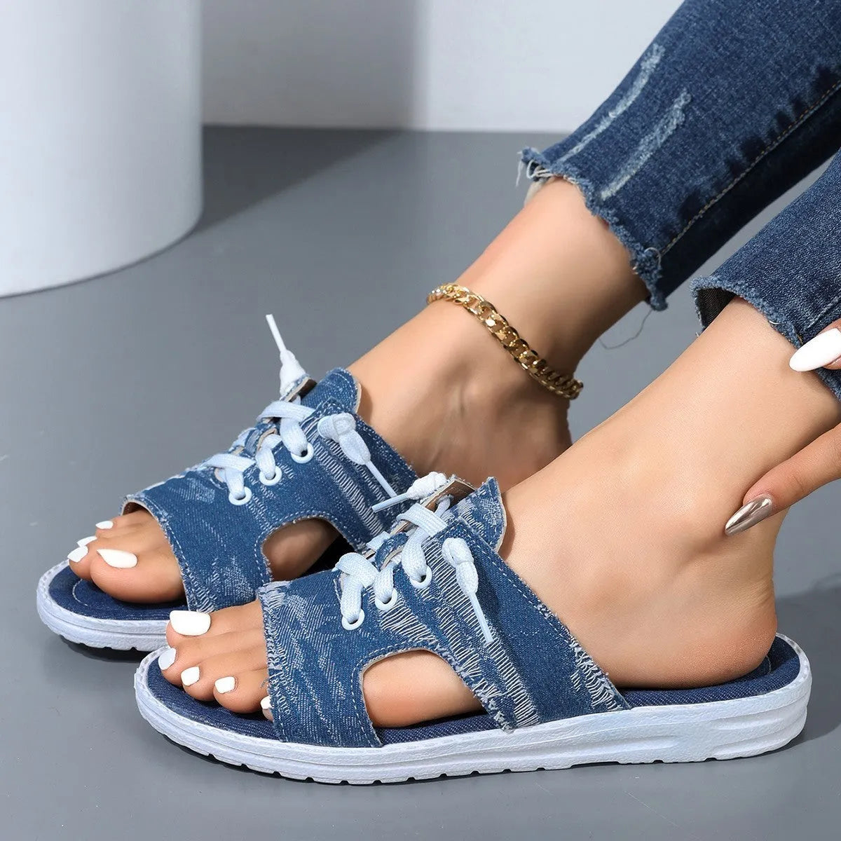 Blue women's flat canvas Roman slippers with a cloth upper and rubber sole.
