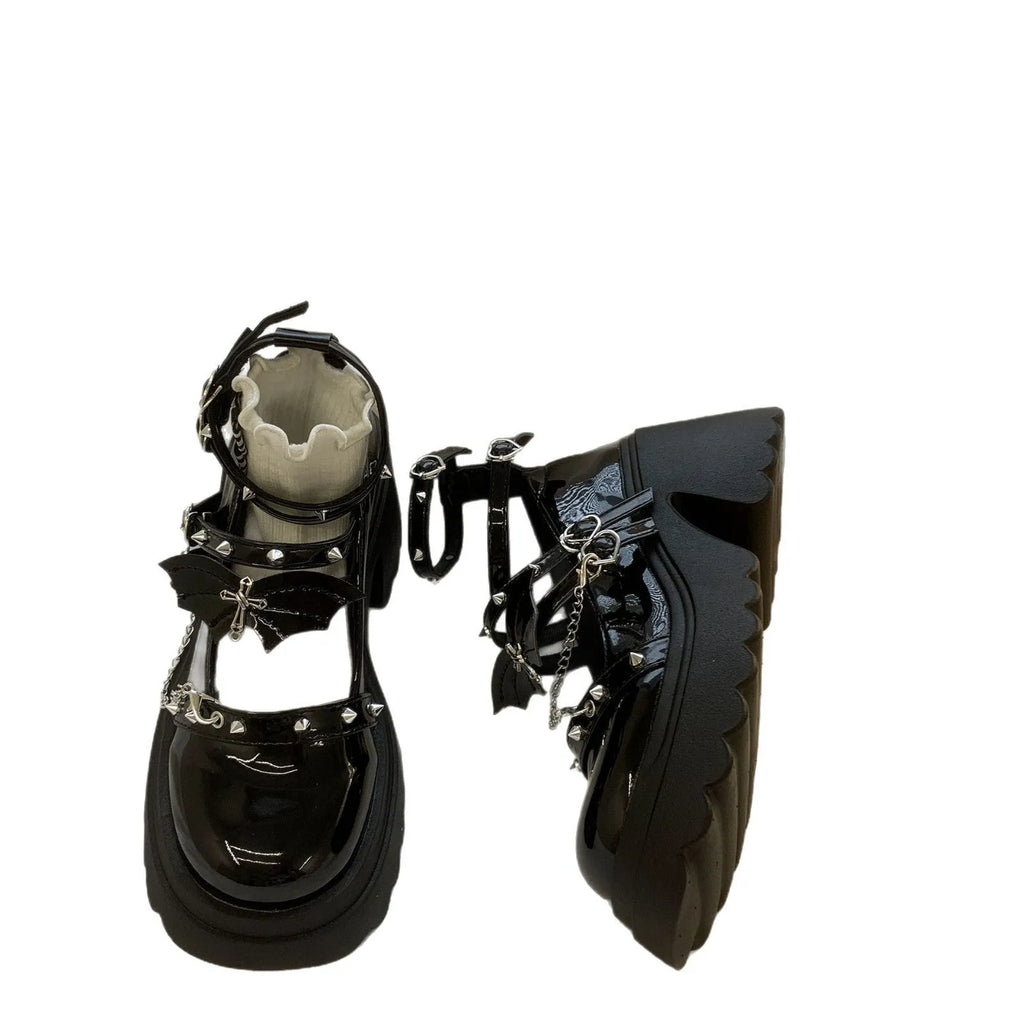 Black patent leather bat cosplay Lolita shoes with metal chain buckle and chunky heel on white background