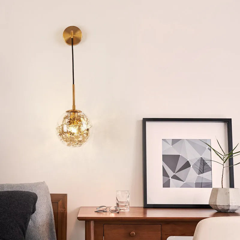 Modern glass wall lamp with golden flower finish and warm white LED light.