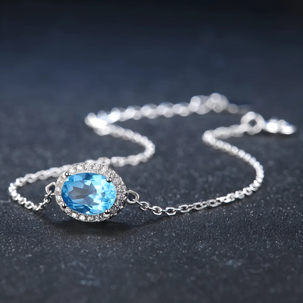 925 sterling silver geometric jewellery set with blue topaz gems showing earrings, ring, necklace, and pendant