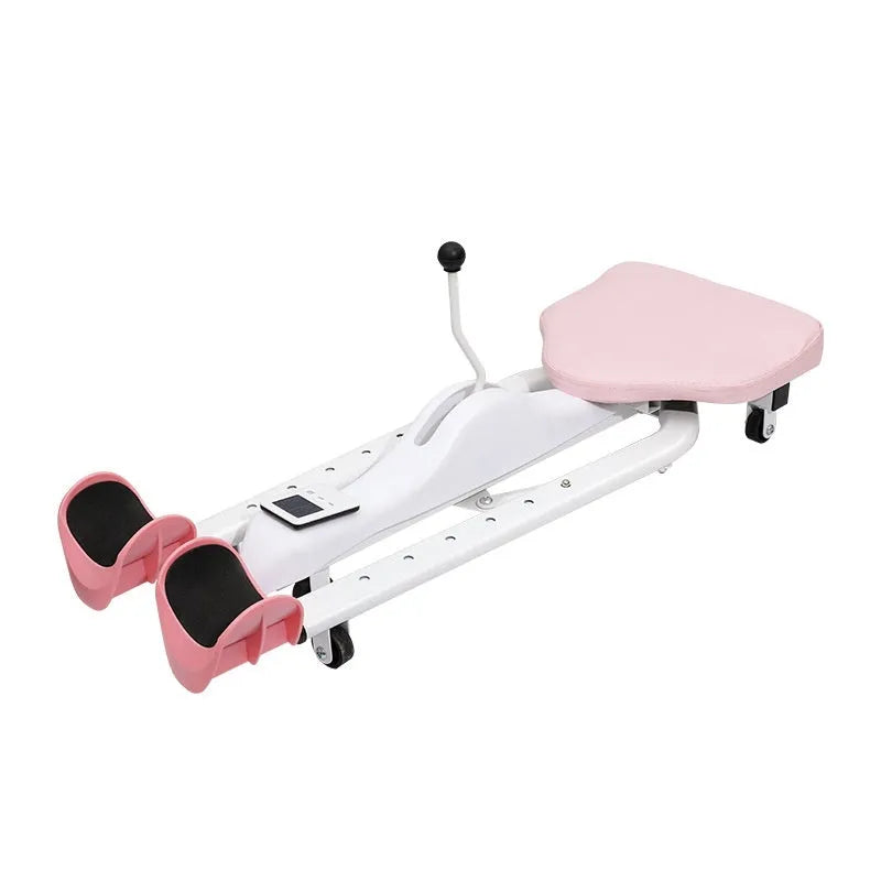 Pink and blue adjustable leg stretching trainer with steel frame and foam padding on a studio floor.