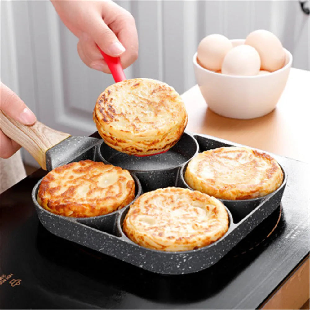 Aluminium four-hole non-stick frying pan with wooden handle for making eggs and burgers.