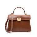 Women's black leather shoulder bag with vachette clasp showing interior zippered compartments