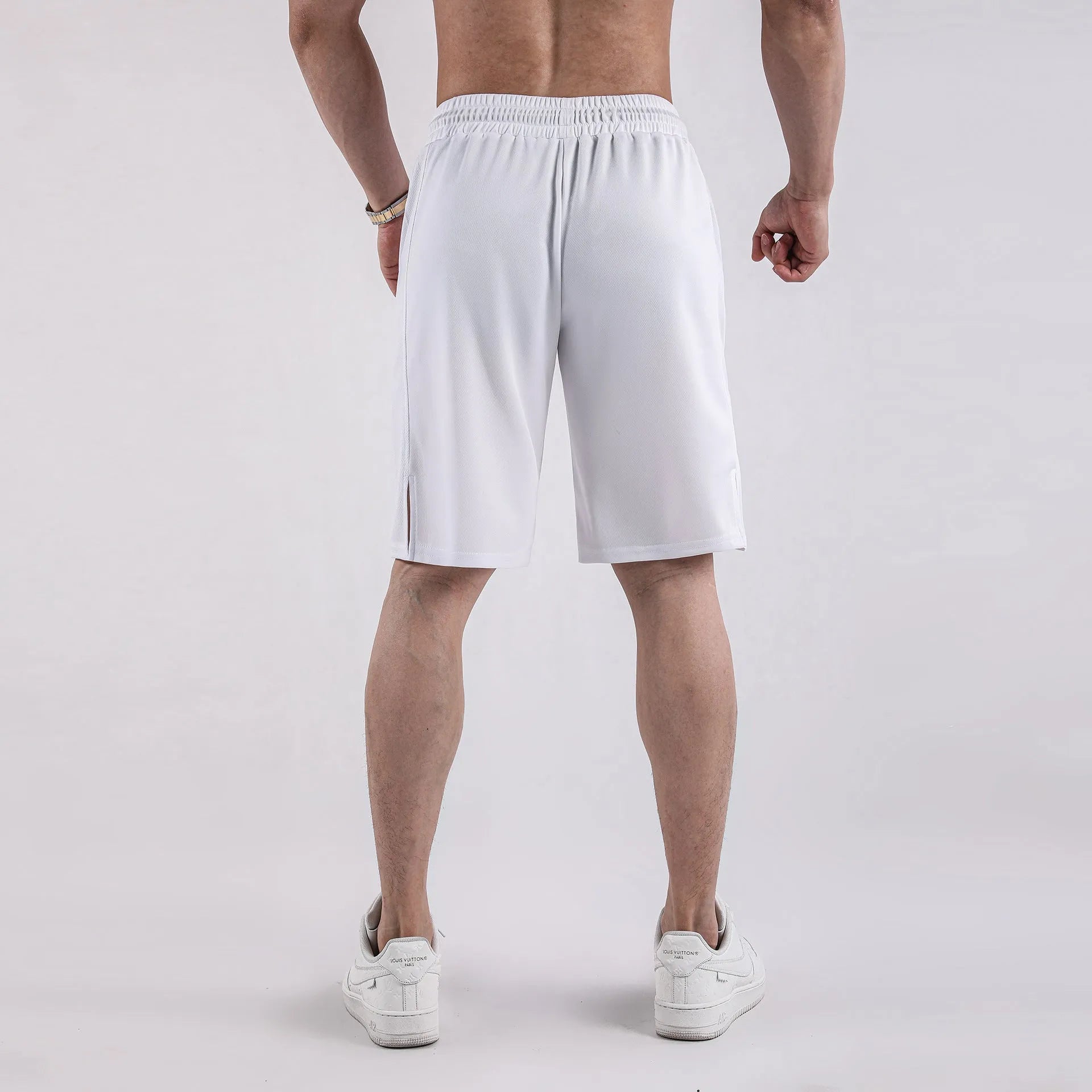 Man wearing loose-fitting black quick-dry mesh fitness shorts with an elasticated waistband.