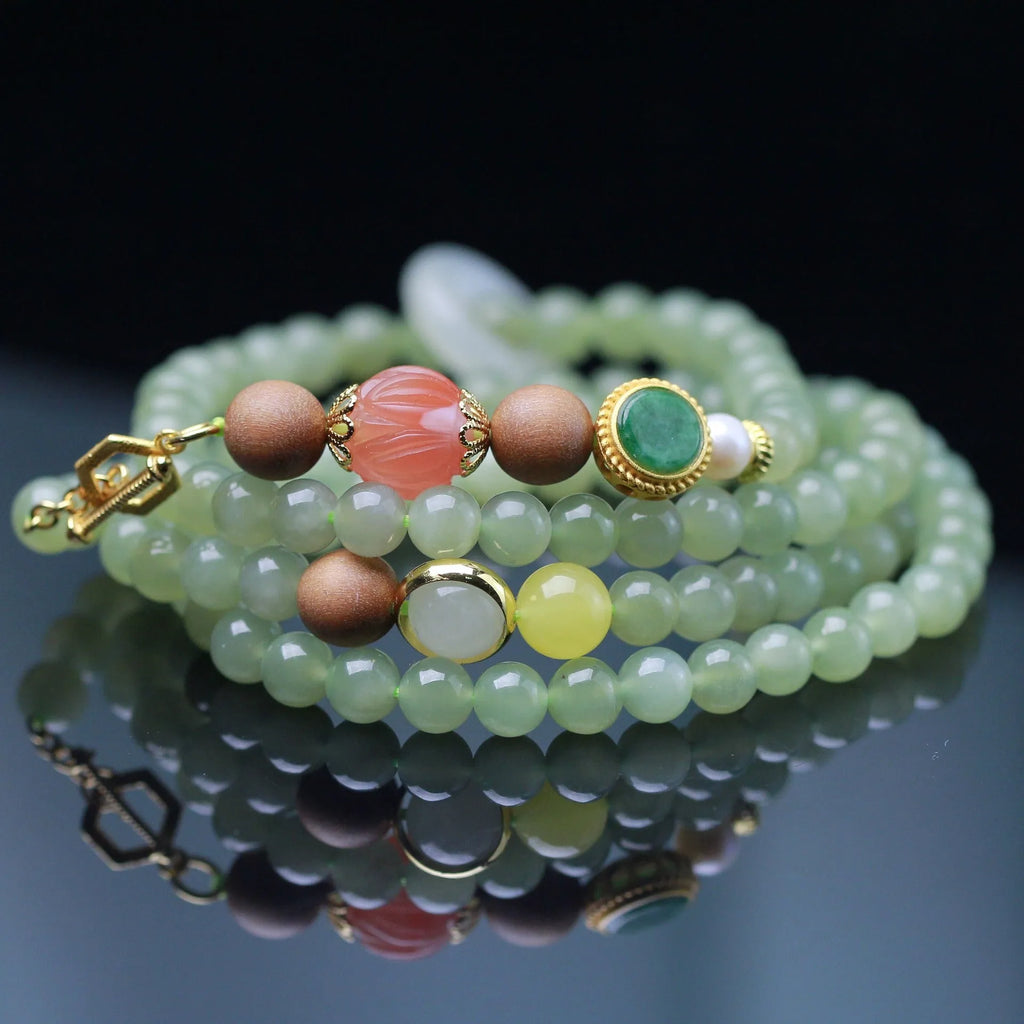 Hetian jade necklace with red lotus beads, white sandalwood, and beeswax, featuring a fu charm and zodiac animal design.