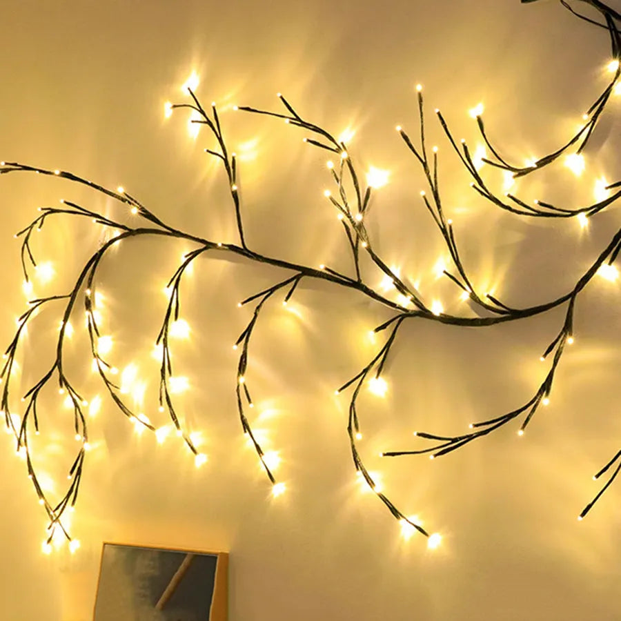 Flexible LED willow vine light garland with warm white bulbs shaped on a wall.