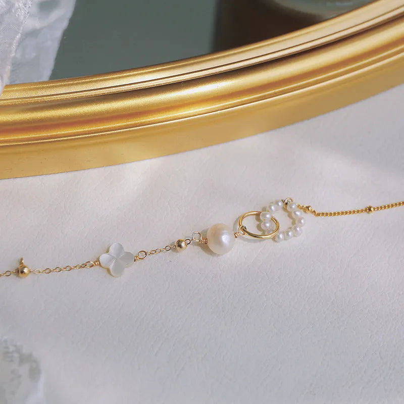 Women's natural pearl bracelet with 14k gold-plated clasp and chain.