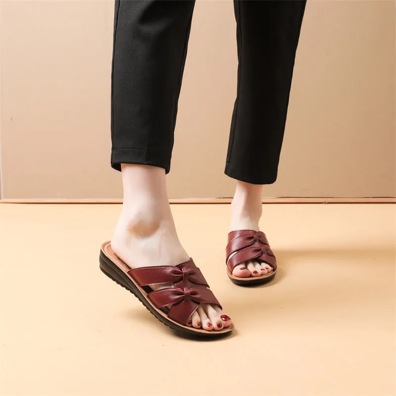 Women's beige cowhide leather slippers with a non-slip sole shown on a white background.